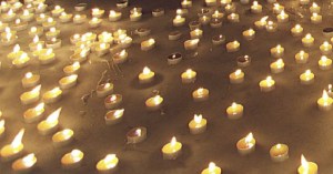 Redusters ontsteken evenveel kaarsjes als handrtekeningen voor Amnesty. In het midden schaatser Ids Postma en burgemeester Ype Dijkstra die de grote kaars aan staken. Doordat er teveel wind stond werd de stunt in de werkplaats van Fetze Tigchelaar gehouden.